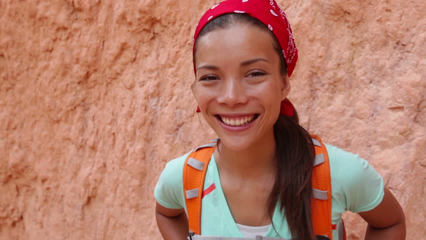 Beautiful smiling girl wearing backpack on hike