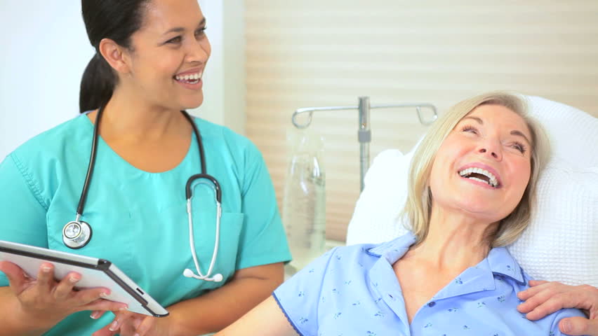 Portrait elderly female patient hospital bed being reassured by medical professionals