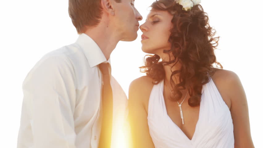 Passionate newlyweds at sunset. Sensual kisses and hugs