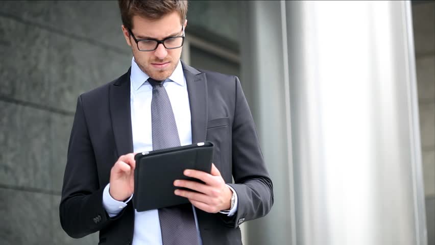  Businessman using electronic tablet outside a building 