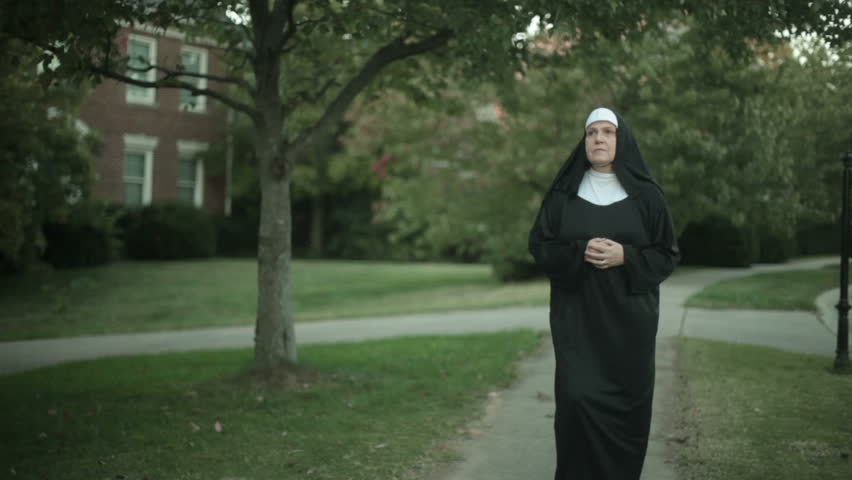 Nun walking down street, focus follows her