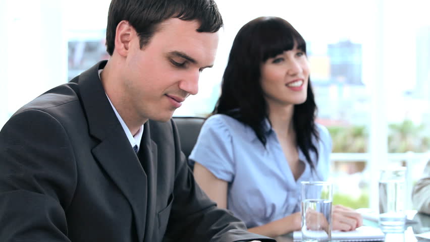 Happy work team talking together in a bright room