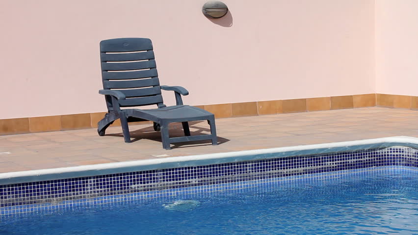empty sunbed at swimming pool