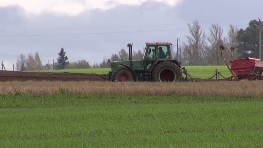 tractor with sowing machine on autumn field