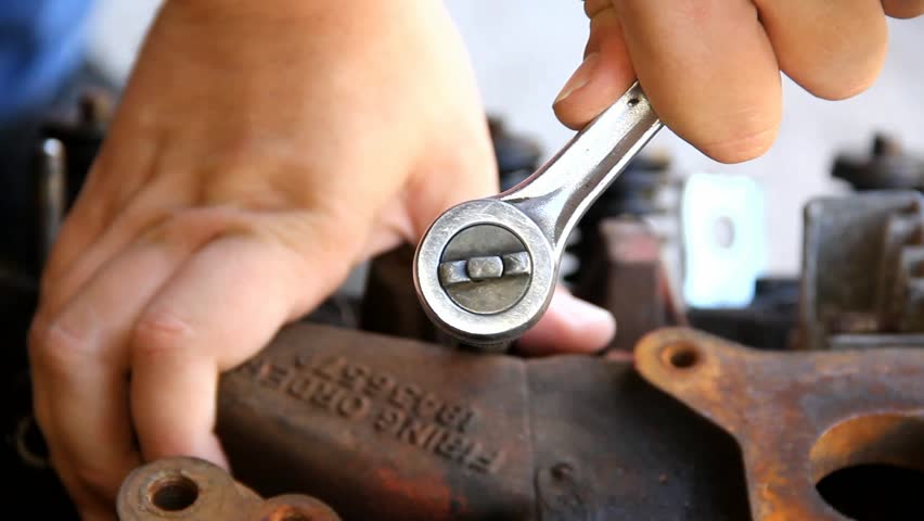 Ratchet Wrench Being Turned On Old Engine Intake Manifold With Firing Order Digits Showing