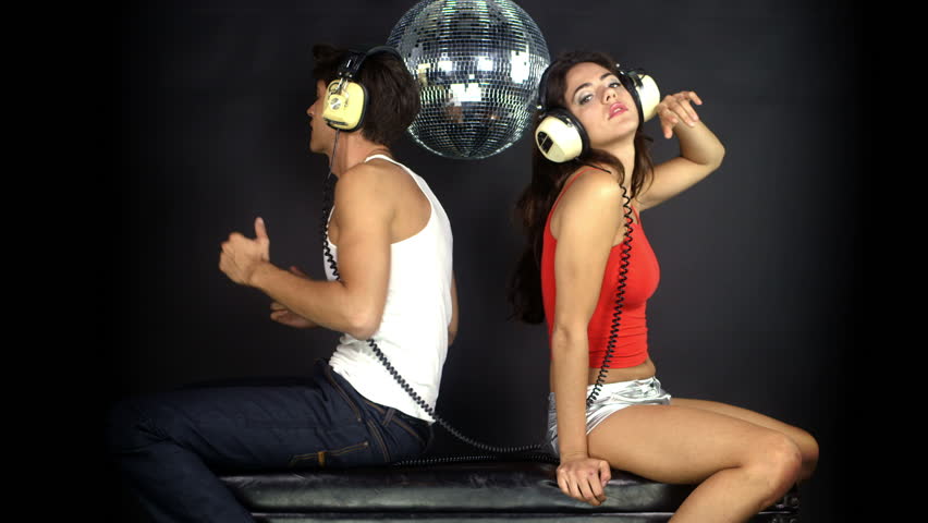 young couple listening to music on headphones, posing and flirting together