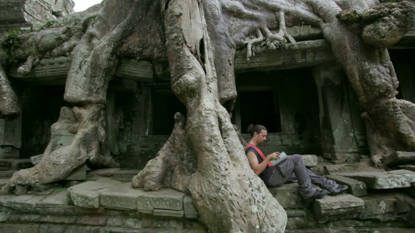 Young man reading book in preah khan temple, Angkor