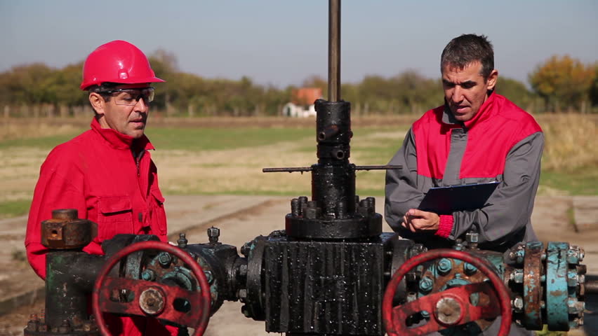 Oil Workers at Well Pump Jack Site.
Engineer giving orders to oil worker next to pump jack. HD1080p. 