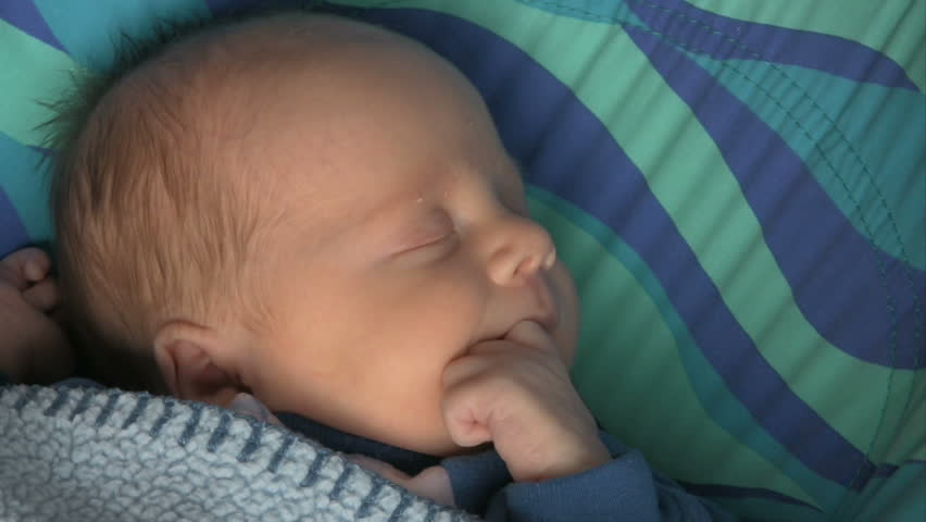 Newborn baby boy sleeping and then begins to wake up and cry.  HD 1080i