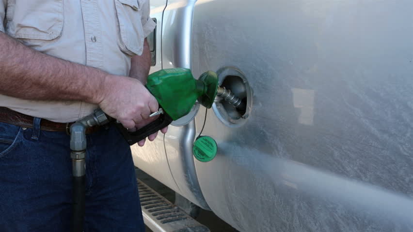 Man filling truck gas tank diesel fuel. Person at station re fuel for a road trip. Expensive cost of living caused by environmental regulations. Need for USA to become energy independent.