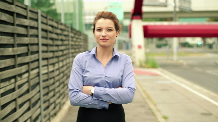 Young happy businesswoman walking in the city, steadicam shot
