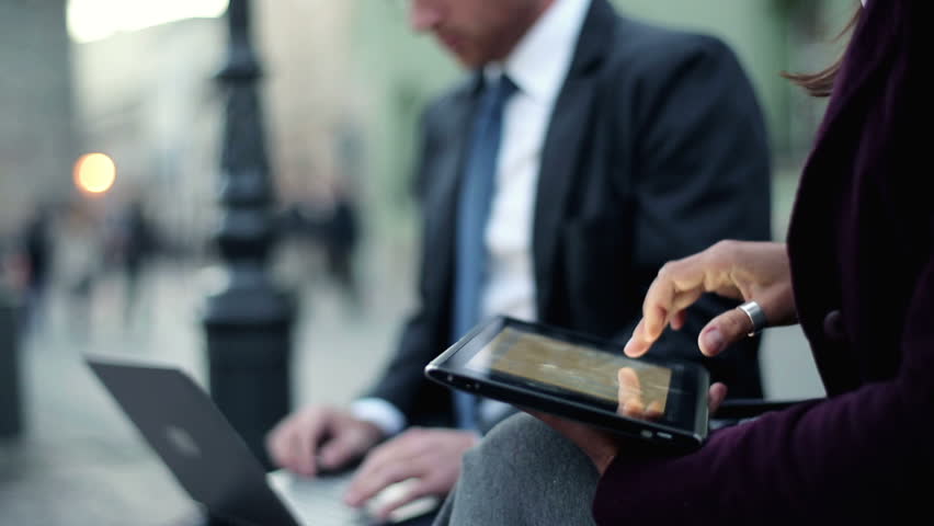 Businesswoman working on tablet computer in the city, steadicam shot