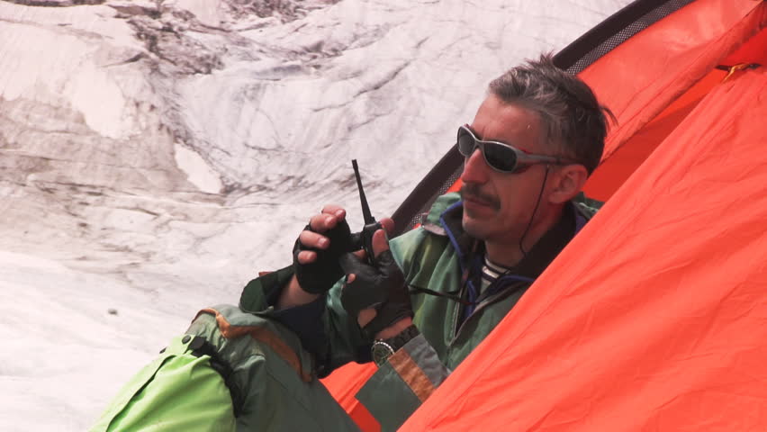 Man in red tent with portable radio