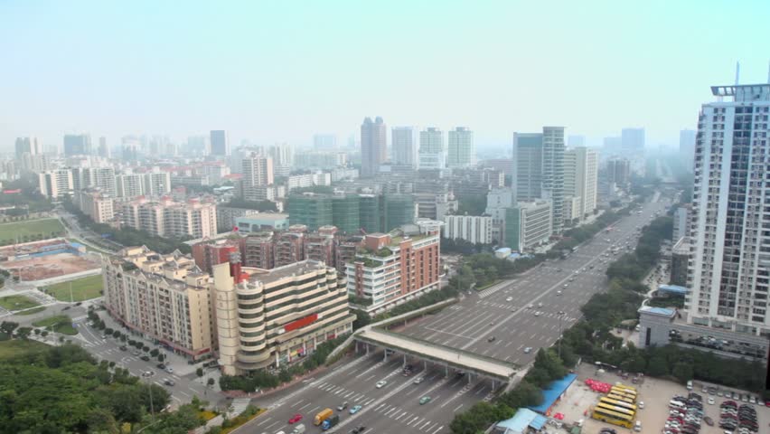Buildings, road with overhead crossing, cars, busses at summer day in Guangzhou, China
