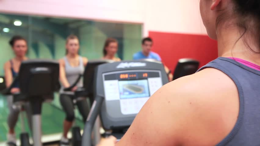 Trainer teaching spin class in gym