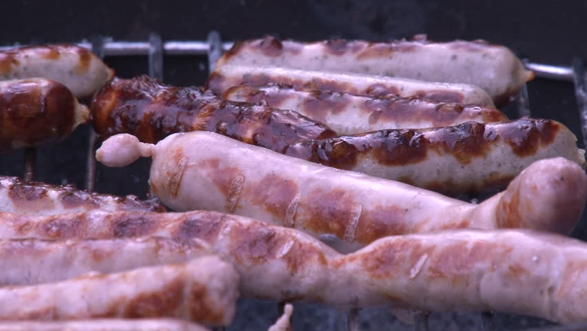 HD close-up video of sausage being cooked on a barbecue. Cooked and sizzling
