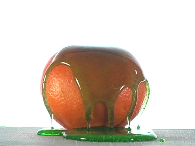Special-effect :  green syrup lifts off of an orange.  The syrup could be apple flavor, mint flavor, or ???