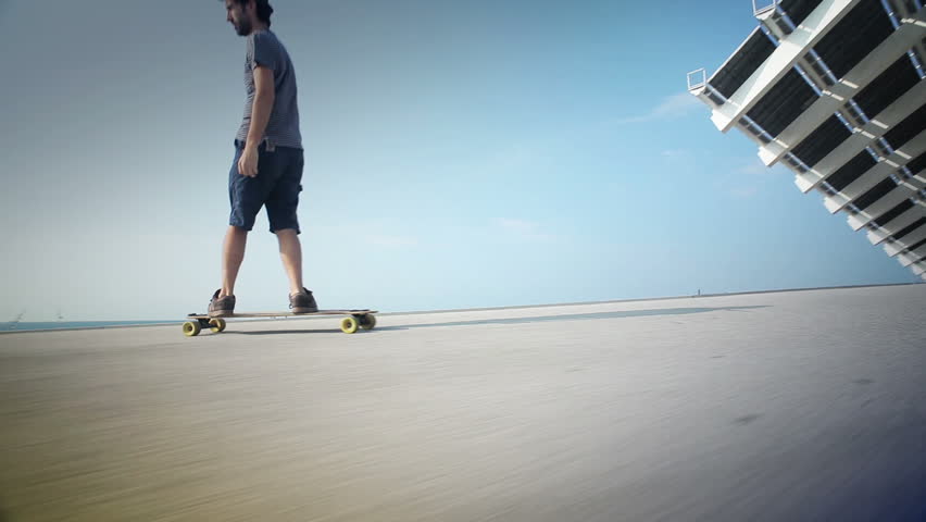 lateral view of a guy on his longboard skate, in Barcelona, Spain.
