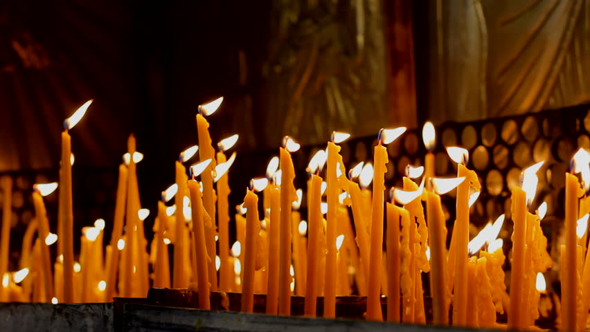 Many burning candles inside a romanian monastery