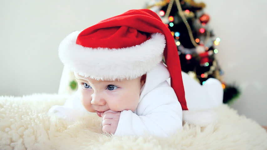 Baby in Christmas hat on the new year background