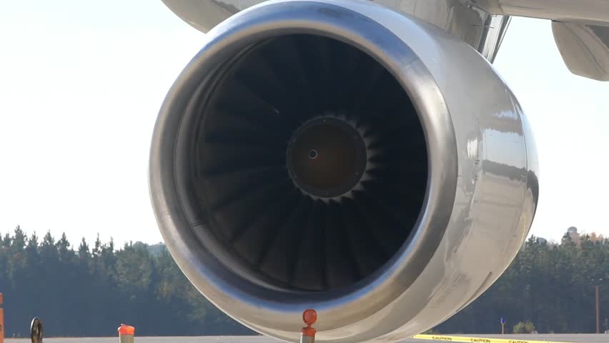 Jet Engine Turbine Blades Spin Slowly On A Windy Day With Caution Tape In The Background