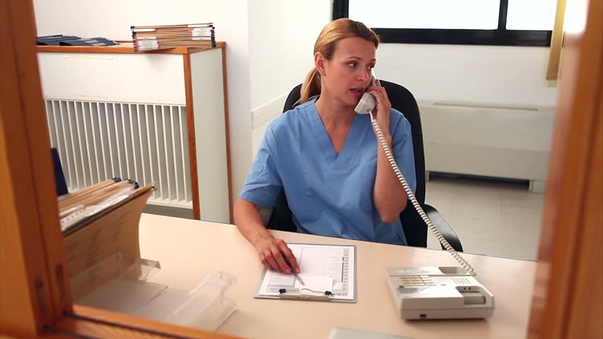 Nurse holding a phone and shaking hand of a patient in hospital reception