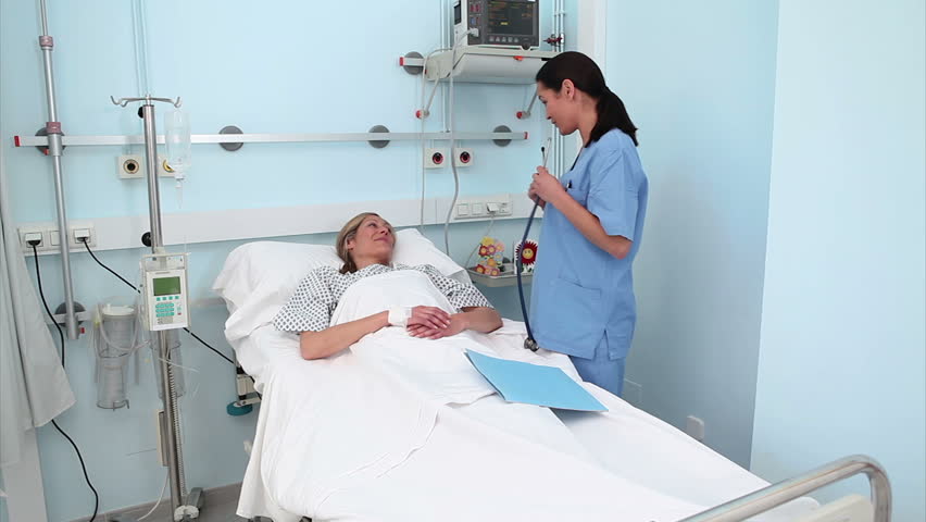 Video of a nurse examining a patient with a stethoscope in hospital ward