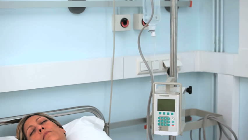 Female patient sleeping on a medical bed in hospital ward