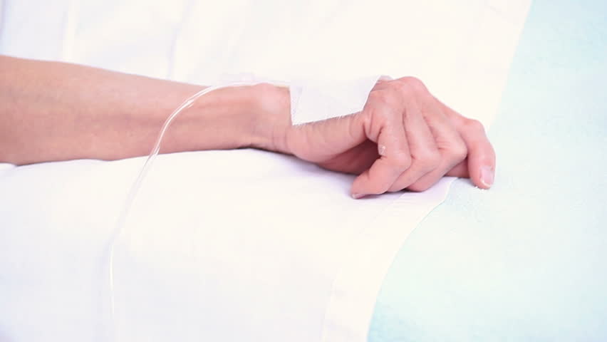 Elderly patient sleeping on a medical bed in hospital ward