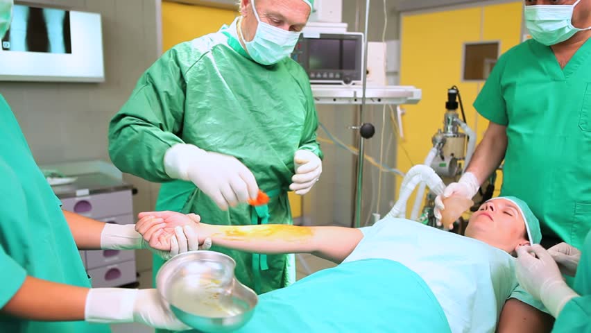 Video of a surgeon disinfecting the arm of a patient in an operating theatre