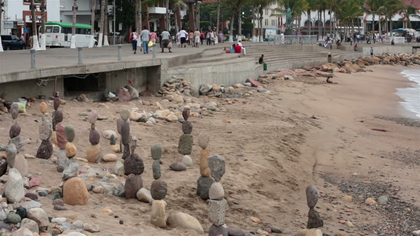 PUERTO VALLARTA MEXICO, NOV 2012: Malecon Boardwalk beach balance rocks. Beach tourist beach of Banderas Bay at Pacific Ocean. Men work for tips and recognition to balance large odd shaped rocks.