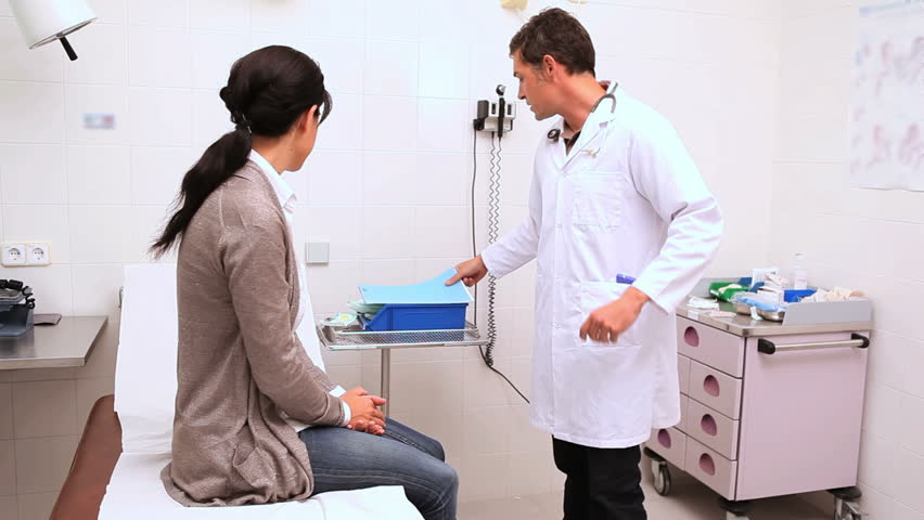 Doctor checking the reflexes of the knee of a patient in an examination room