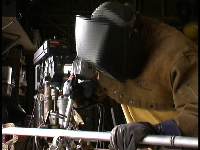 person welding aluminum pipe with spool gun
