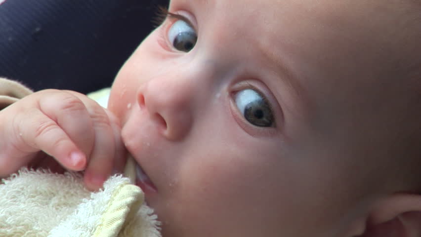 Five months old baby chewing his hands 
