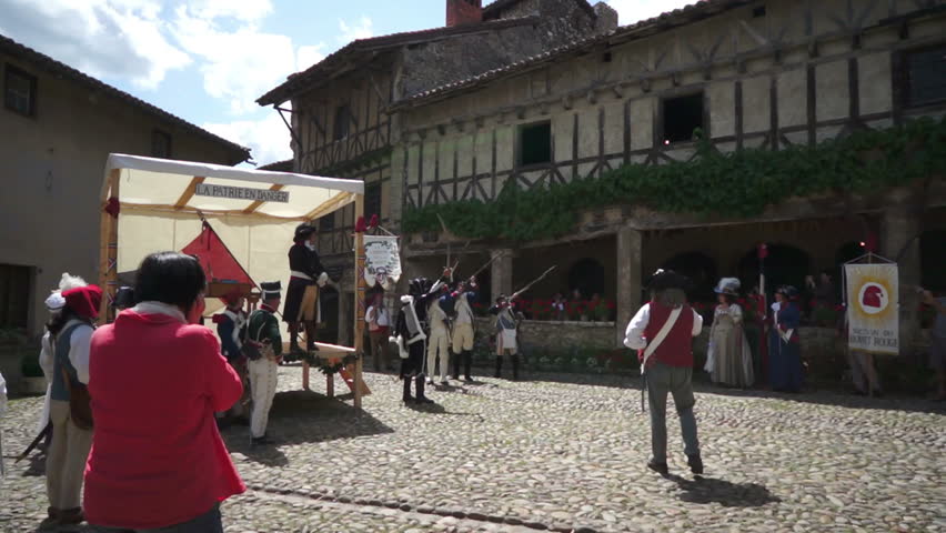 PEROUGES, FRANCE - JULY 14, 2012: Scene of the historic commemoration of the French Revolution, celebrated every year by many folks who wear the common clothes of that time; here some shooting blanks