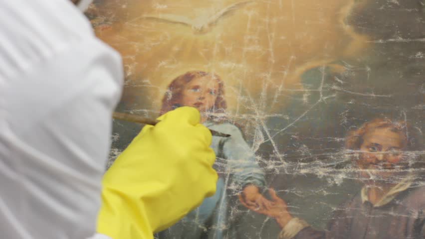 restorer at work on damaged ancient painting, close up