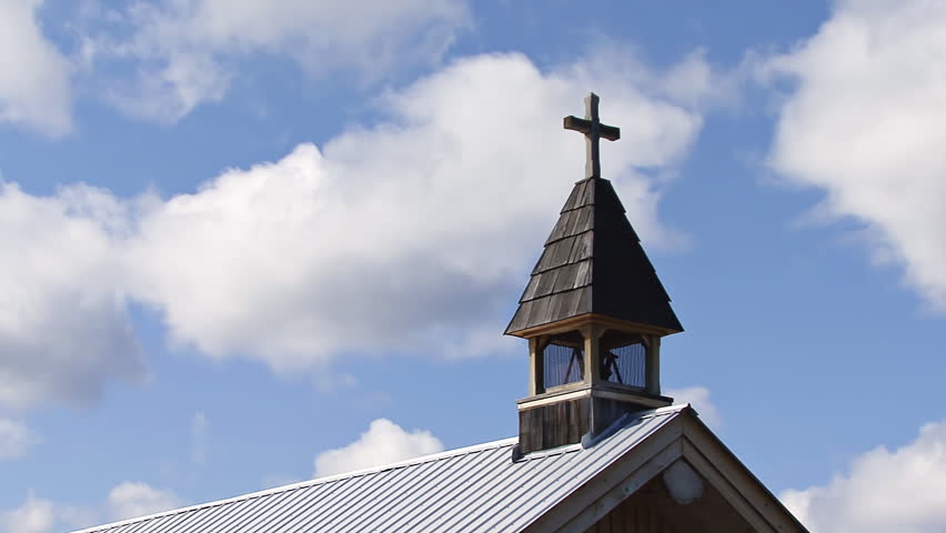 A cloud and shadow timelapse shot with the steeple of the church at the 108-Mile Roadhouse Historical Site in British Columbia in the foreground.