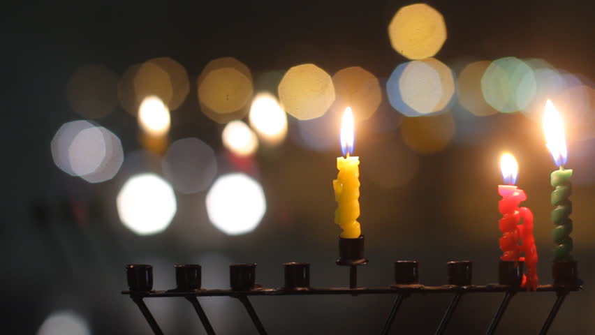 Beautiful candles and Hanukkah menorah with defocused background, dolly shot. 