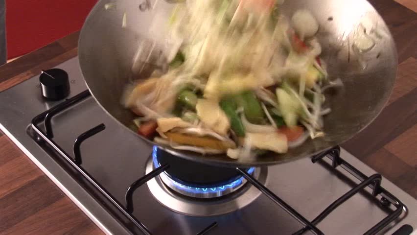 Tossing vegetables and sprouts in a wok