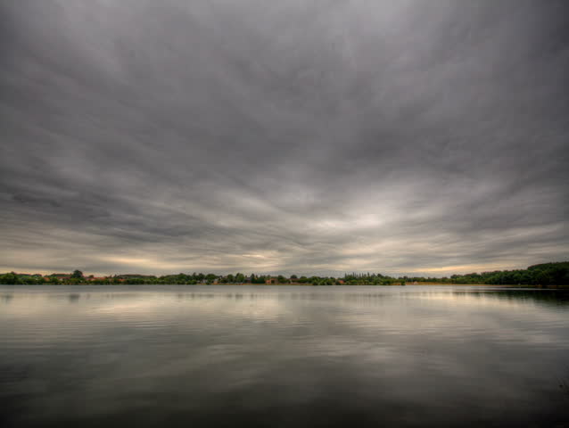 Impressive storm clouds over lake, HD time lapse clip, high dynamic range imaging.