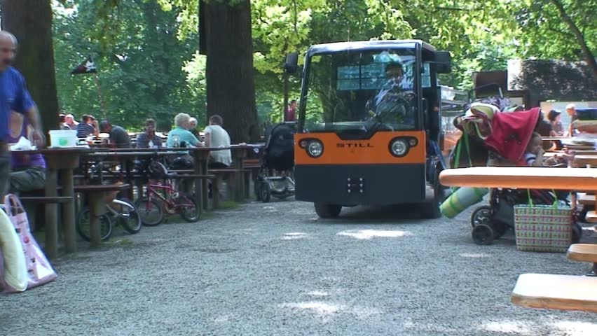 MUNICH, GERMANY - CIRCA 2011: A small van that collects empty glasses drives through a Munich beer garden.