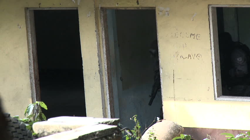 Two airsoft players move from room to room in slow motion.