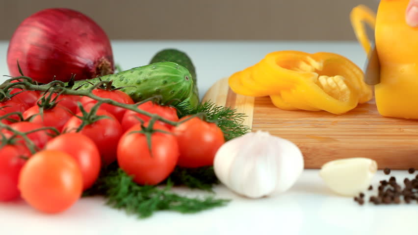 Female hands slicing yellow paprika(pepper)