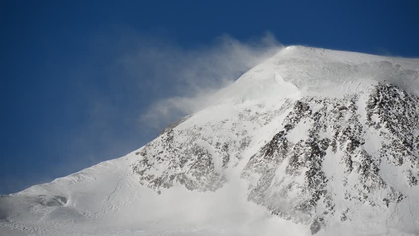 Strong wind over glacial mountain ridge of Alphubel mountain peak, Saas Fee, Valais, Switzerland