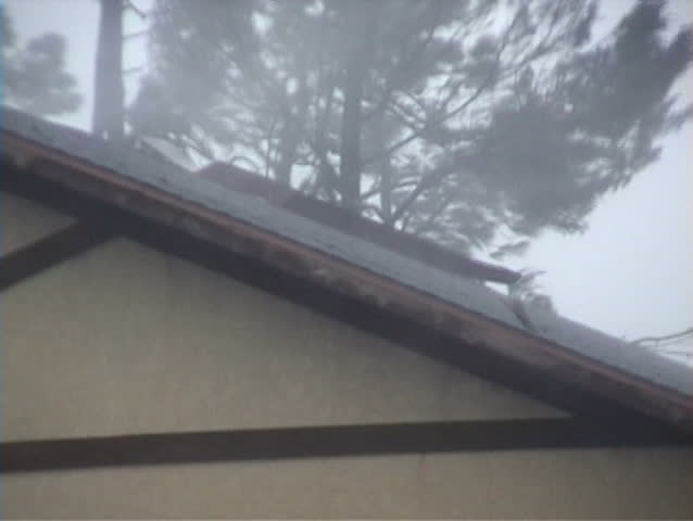 A roof getting torn apart during a hurricane.