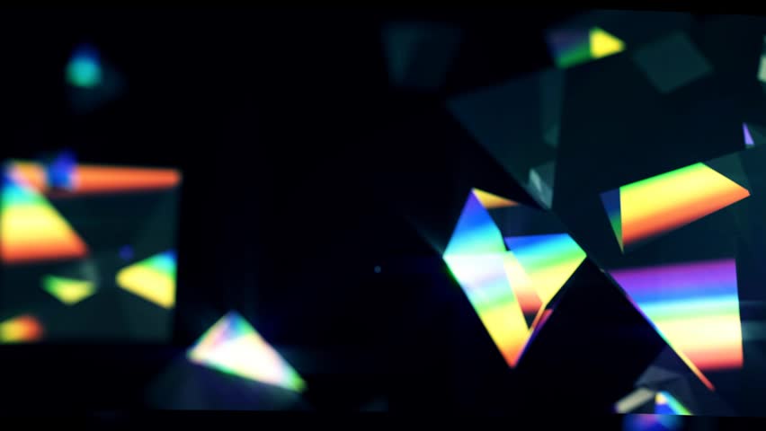 Rainbow triangle prisms float close up on black background