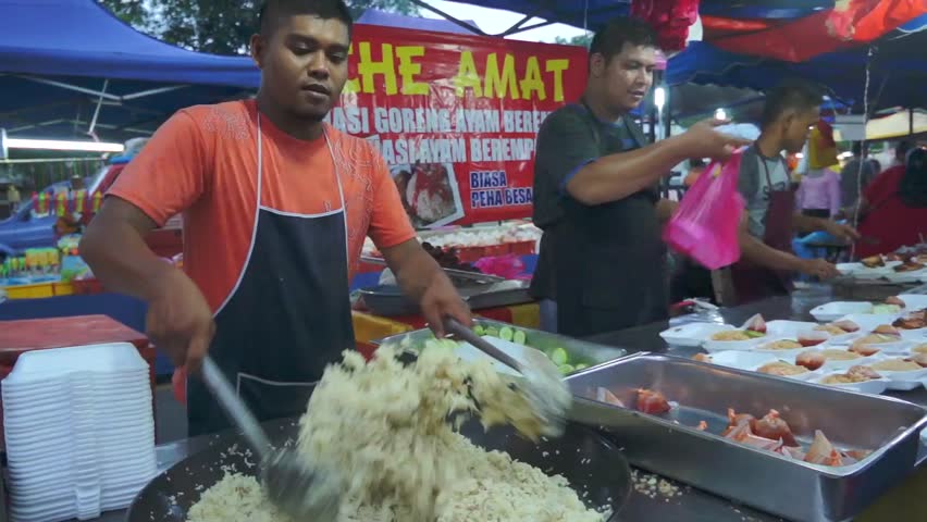 KUALA LUMPUR - JAN 12 : Food seller demonstrates how to cook fried rice at a night market in Kuala Lumpur, Malaysia on January 12, 2013