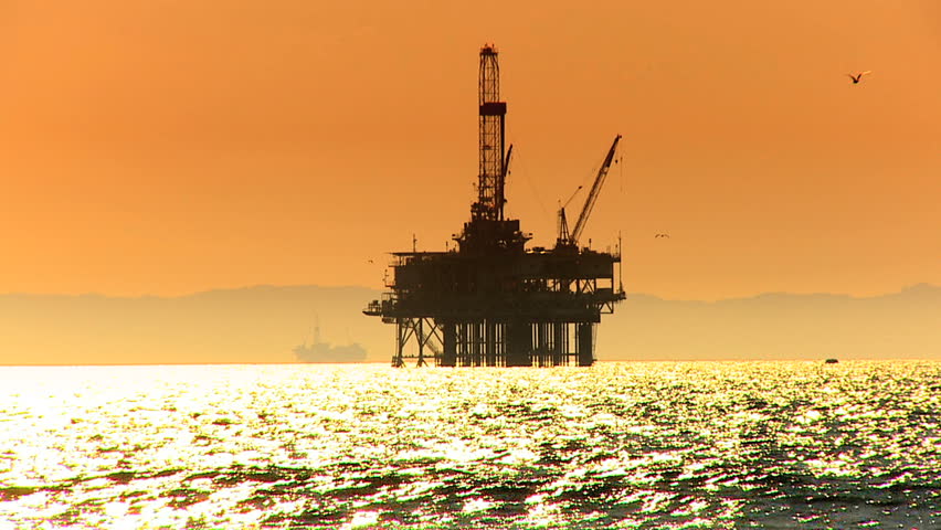Oil platform in the sea at sunset