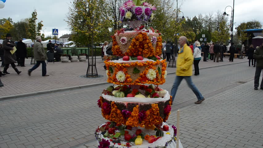 SIRVINTOS, LITHUANIA - CIRCA OCTOBER 2012: Cake shape imitation decoration made of autumn flowers and fruits people walk in outdoor autumn harvest festival event on circa October, 2012 in Sirvintos.