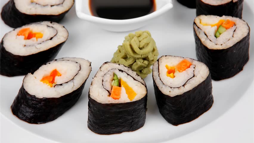Japanese Traditional Cuisine - California Roll with Salmon (sake) Cream Cheese and Tuna (maguro) . on white dish with sticks isolated over white background